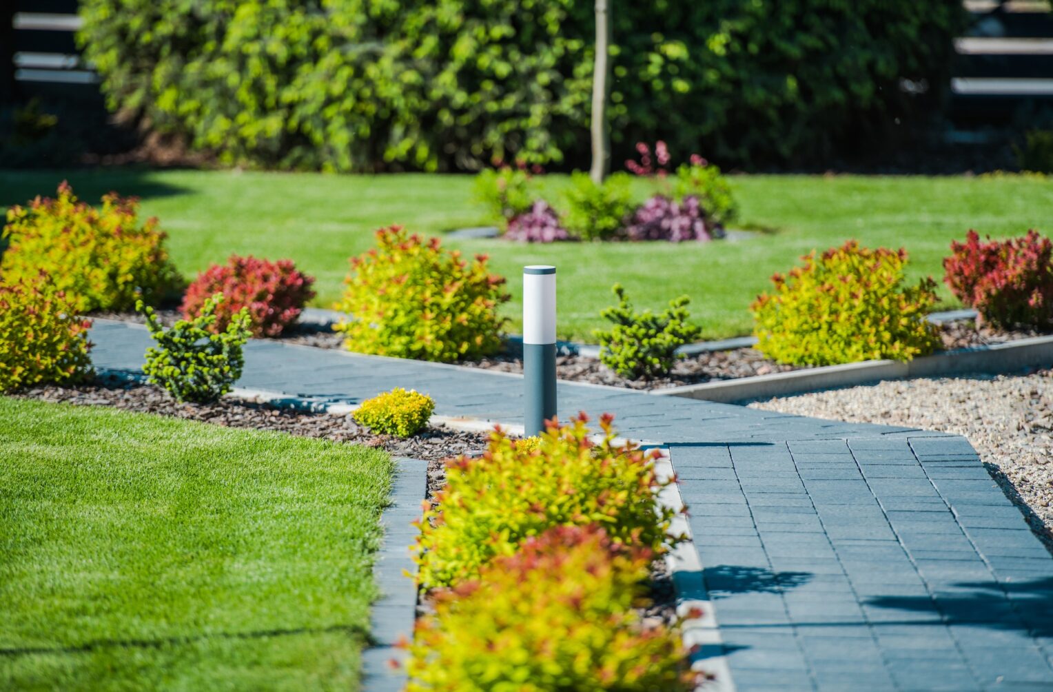 Moderner Garten mit Pflasterweg und Beleuchtung